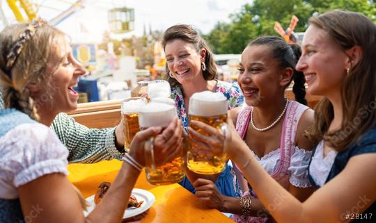 Group of women in traditional tracht dresses toasting with beer mugs at oktoberfest in germany festival, amusement park in background  : Stock Photo or Stock Video Download rcfotostock photos, images and assets rcfotostock | RC Photo Stock.: