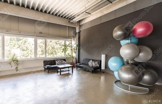 Gym for fitness exercises. With fitballs and couch. The room is flooded with daylight sunlight from the window, the glare on the dark wall.  : Stock Photo or Stock Video Download rcfotostock photos, images and assets rcfotostock | RC Photo Stock.: