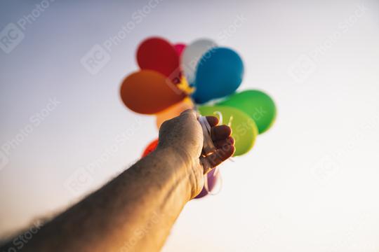 hand holding bunch of Colorful balloons  : Stock Photo or Stock Video Download rcfotostock photos, images and assets rcfotostock | RC Photo Stock.: