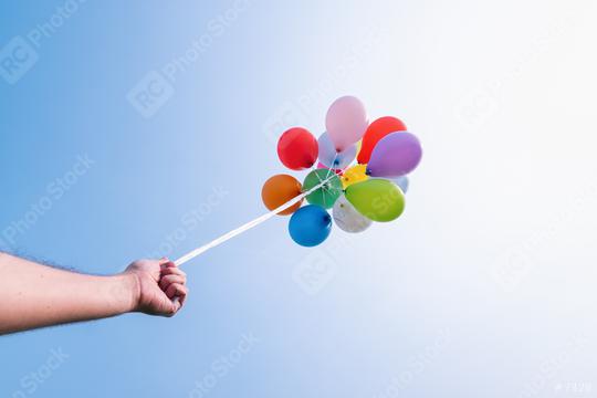 hand holding Colorful balloons against blue sky  : Stock Photo or Stock Video Download rcfotostock photos, images and assets rcfotostock | RC Photo Stock.: