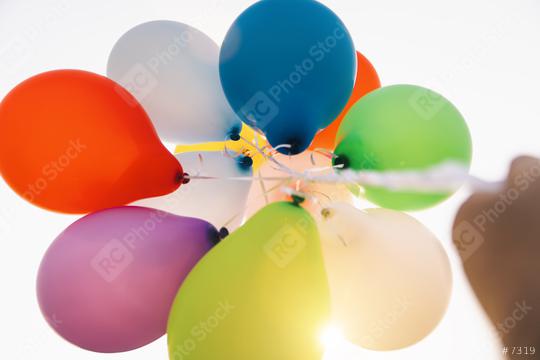 hand holding Colorful balloons against sun  : Stock Photo or Stock Video Download rcfotostock photos, images and assets rcfotostock | RC Photo Stock.:
