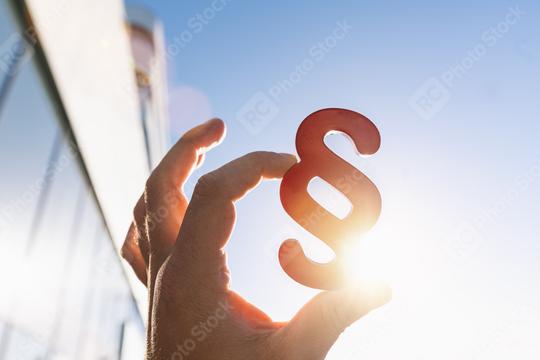 Hand holds paragraph in the sun as a sign of justice   : Stock Photo or Stock Video Download rcfotostock photos, images and assets rcfotostock | RC Photo Stock.: