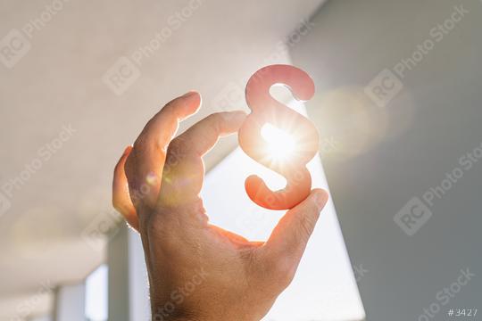 Hand holds paragraph symbol in the sun  at a office building  : Stock Photo or Stock Video Download rcfotostock photos, images and assets rcfotostock | RC Photo Stock.: