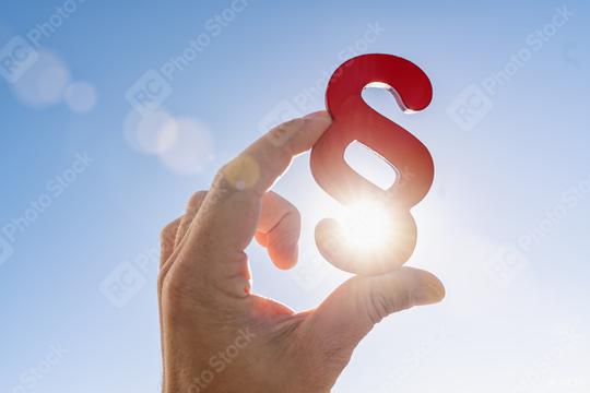 Hand holds paragraph symbol in the sun in the sky  : Stock Photo or Stock Video Download rcfotostock photos, images and assets rcfotostock | RC Photo Stock.: