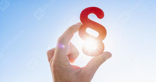 Hand holds paragraph symbol in the sun in the sky  : Stock Photo or Stock Video Download rcfotostock photos, images and assets rcfotostock | RC Photo Stock.: