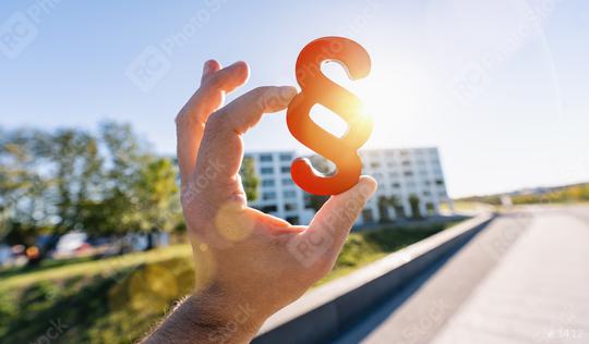 Hand holds red paragraph sign in the sun as a symbol for idea of law and justice  : Stock Photo or Stock Video Download rcfotostock photos, images and assets rcfotostock | RC Photo Stock.: