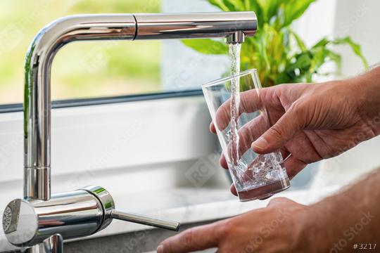 hand pours water into a glass from faucet at the kitchen  : Stock Photo or Stock Video Download rcfotostock photos, images and assets rcfotostock | RC Photo Stock.: