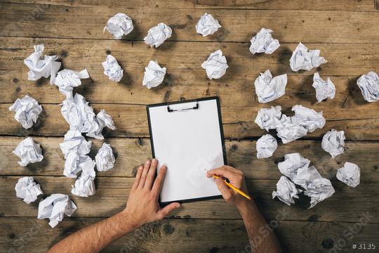 Hands holding clipboard and write Mock-up or ideas with a pen surrounded from crumpled paper balls. Brainstorming Concept image  : Stock Photo or Stock Video Download rcfotostock photos, images and assets rcfotostock | RC Photo Stock.: