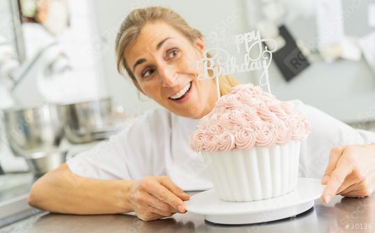 happy confectioner smiling and holding big Birthday cake muffin with candies at pastry bakery  : Stock Photo or Stock Video Download rcfotostock photos, images and assets rcfotostock | RC Photo Stock.: