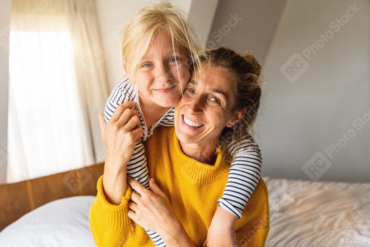 Happy daughter giving mother piggybacking smiling at camera. Good time at home concept image  : Stock Photo or Stock Video Download rcfotostock photos, images and assets rcfotostock | RC Photo Stock.: