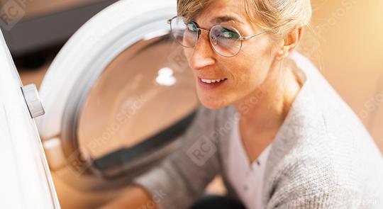 Happy Housewife at the washing machine or dryer in the kitchen room   : Stock Photo or Stock Video Download rcfotostock photos, images and assets rcfotostock | RC Photo Stock.: