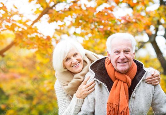 Happy senior couple enjoying a warm autumn day outdoors with colorful foliage in the background, expressing love, warmth, and companionship in cozy scarves and sweaters  : Stock Photo or Stock Video Download rcfotostock photos, images and assets rcfotostock | RC Photo Stock.: