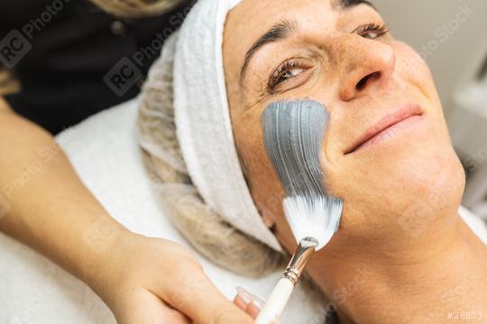 happy woman gets mud mask on face for rejuvenation at the cosmet  : Stock Photo or Stock Video Download rcfotostock photos, images and assets rcfotostock | RC Photo Stock.: