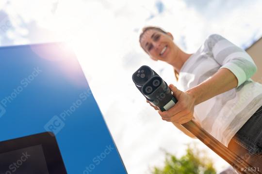 Happy woman holding a DC CCS2 EV charging connector on a 300KW H  : Stock Photo or Stock Video Download rcfotostock photos, images and assets rcfotostock | RC Photo Stock.: