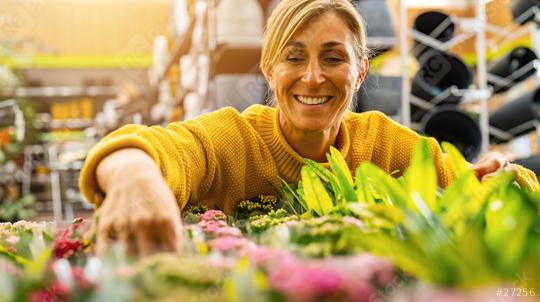 Happy woman in a bright yellow sweater is closely examining and choosing plants in an indoor garden center, surrounded by lush greenery. Shopping in a greenhouse concept image  : Stock Photo or Stock Video Download rcfotostock photos, images and assets rcfotostock | RC Photo Stock.: