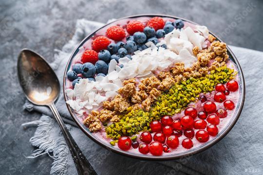 Healthy breakfast bowl, wirh blueberry smoothie with, raspberry, blueberrys, coconut, nuts and currants toppings on a table with spoon  : Stock Photo or Stock Video Download rcfotostock photos, images and assets rcfotostock | RC Photo Stock.: