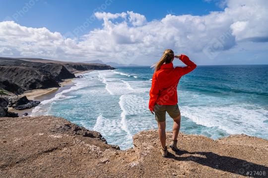 Hiker in red jacket looking out at the ocean waves from a cliff on a sunny day  : Stock Photo or Stock Video Download rcfotostock photos, images and assets rcfotostock | RC Photo Stock.: