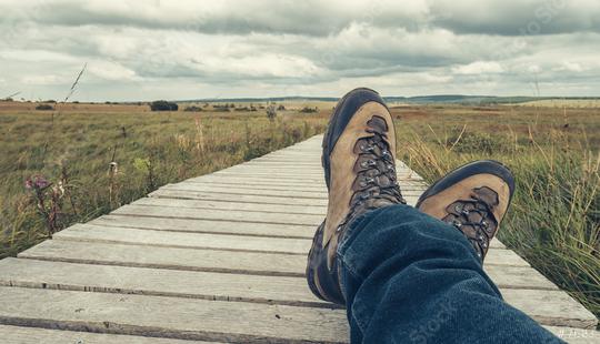 Hiking boots of a hiker while taking a rest on a wooden boardwalk, point of view.  : Stock Photo or Stock Video Download rcfotostock photos, images and assets rcfotostock | RC Photo Stock.:
