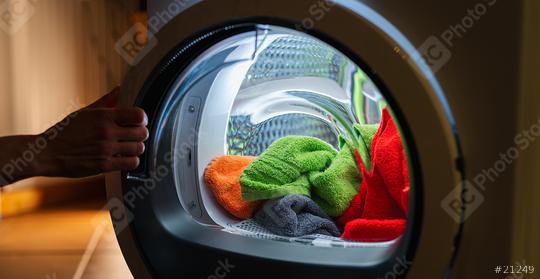 Housewife opens a  washing machine or dryer at night with many colorful clean fresh hand towels  : Stock Photo or Stock Video Download rcfotostock photos, images and assets rcfotostock | RC Photo Stock.: