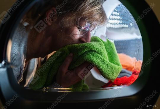 Housewife smells on clean laundry fresh from washing machine or dryer  : Stock Photo or Stock Video Download rcfotostock photos, images and assets rcfotostock | RC Photo Stock.: