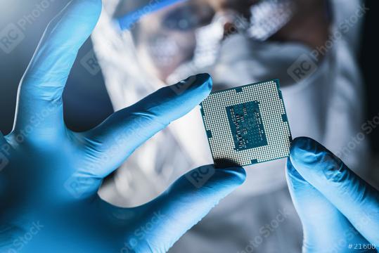 In Ultra Modern Electronic Manufacturing Factory Design Engineer in Sterile Coverall Holds Microchip with Gloves and Examines it  : Stock Photo or Stock Video Download rcfotostock photos, images and assets rcfotostock | RC Photo Stock.: