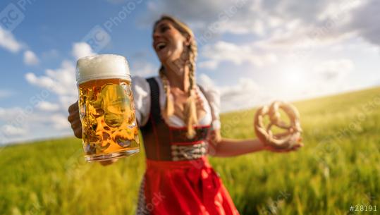 Joyful Bavarian woman in trach with beer and pretzel in a sunny wheat field celebrating Oktoberfest or dult festival in munich.  : Stock Photo or Stock Video Download rcfotostock photos, images and assets rcfotostock | RC Photo Stock.: