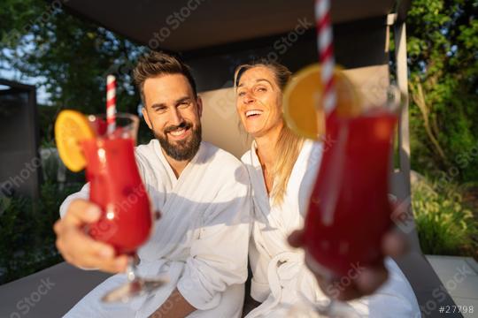 joyful couple in white spa robes enjoying red cocktails at a wellness resort  : Stock Photo or Stock Video Download rcfotostock photos, images and assets rcfotostock | RC Photo Stock.: