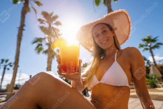 joyful woman in a white bikini and straw hat toasts with a tropical cocktail, palm trees in the background at caribbean island hotel   : Stock Photo or Stock Video Download rcfotostock photos, images and assets rcfotostock | RC Photo Stock.: