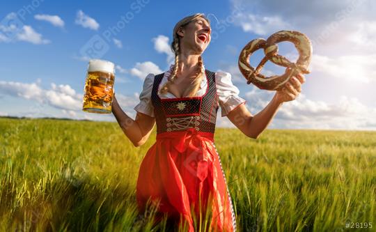 Laughing woman in traditional Bavarian dress holding beer and pretzel in a sunny wheat field celebrating Oktoberfest or dult festival in munich.  : Stock Photo or Stock Video Download rcfotostock photos, images and assets rcfotostock | RC Photo Stock.: