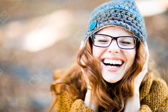 Laughing woman with glasses, red hair, and a knit hat outdoors in a soft autumn background  : Stock Photo or Stock Video Download rcfotostock photos, images and assets rcfotostock | RC Photo Stock.: