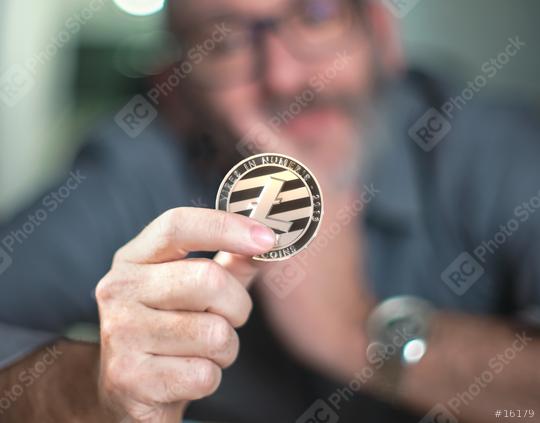 Litecoin cryptocurrency in hand of a casual businessman   : Stock Photo or Stock Video Download rcfotostock photos, images and assets rcfotostock | RC Photo Stock.: