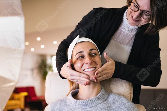 make up assistant applying make up with hand massage of a happy model for a photoshoot or movie on location.  : Stock Photo or Stock Video Download rcfotostock photos, images and assets rcfotostock | RC Photo Stock.: