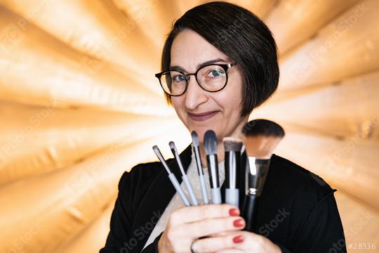 Makeup artist holding a set of makeup brushes at a photostudio  : Stock Photo or Stock Video Download rcfotostock photos, images and assets rcfotostock | RC Photo Stock.: