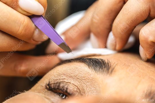 Make-up artist plucks eyebrows with tweezers to a woman. Beautiful thick eyebrows close up. Makeup and Cosmetology concept image  : Stock Photo or Stock Video Download rcfotostock photos, images and assets rcfotostock | RC Photo Stock.: