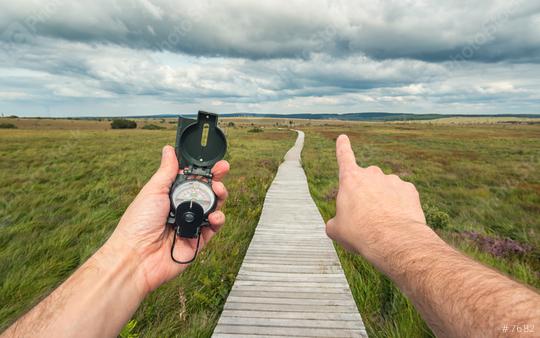Male explorer searching direction with compass and shows the way in to the landscape, point of view.  : Stock Photo or Stock Video Download rcfotostock photos, images and assets rcfotostock | RC Photo Stock.:
