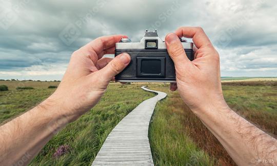 male hand holding a vintage camera against the a bog landscape with wooden boardwalk to take a picture, point of view perspective.  : Stock Photo or Stock Video Download rcfotostock photos, images and assets rcfotostock | RC Photo Stock.: