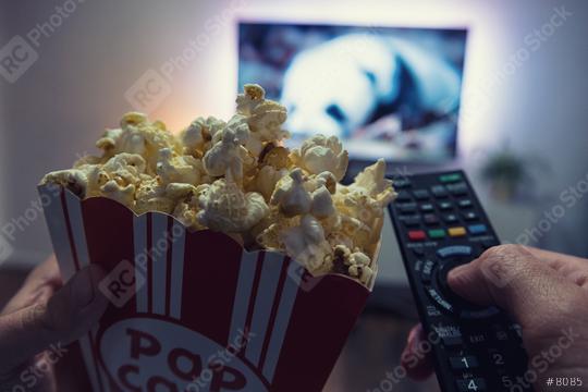 Male hand holding TV remote control and popcorn box, Point of view shot  : Stock Photo or Stock Video Download rcfotostock photos, images and assets rcfotostock | RC Photo Stock.: