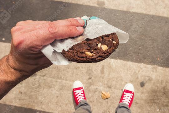 Male person standing on the street with fresh Chocolate Cookie in his hand. First person POV. Top view.  : Stock Photo or Stock Video Download rcfotostock photos, images and assets rcfotostock | RC Photo Stock.: