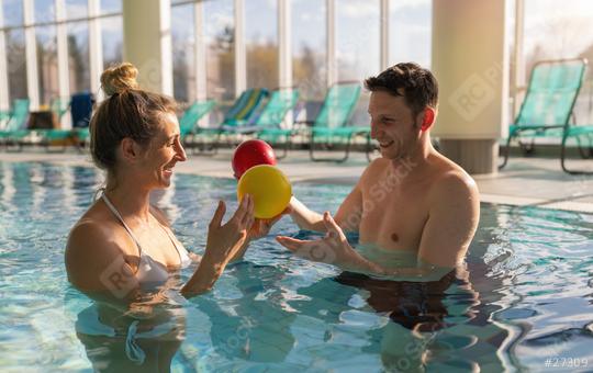 Male trainer and female client happily using colorful exercise balls during a pool therapy session  : Stock Photo or Stock Video Download rcfotostock photos, images and assets rcfotostock | RC Photo Stock.:
