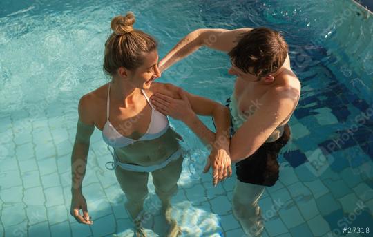 Male trainer assisting a female client with shoulder exercises in a rehabilitation pool session  : Stock Photo or Stock Video Download rcfotostock photos, images and assets rcfotostock | RC Photo Stock.: