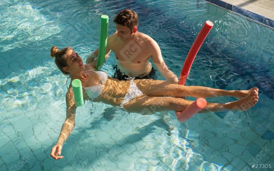 Male trainer using pool noodles to assist a client with rehabilitation exercises in a pool  : Stock Photo or Stock Video Download rcfotostock photos, images and assets rcfotostock | RC Photo Stock.: