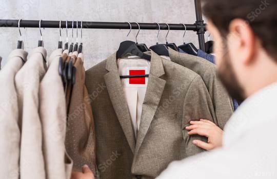 Man browsing through various suit jackets on a rack in a store  : Stock Photo or Stock Video Download rcfotostock photos, images and assets rcfotostock | RC Photo Stock.: