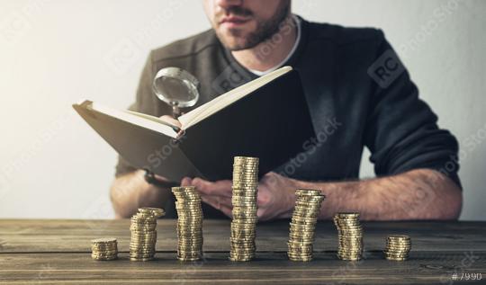 Man Checking Finances using magnifying glass with coins on stacks  : Stock Photo or Stock Video Download rcfotostock photos, images and assets rcfotostock | RC Photo Stock.: