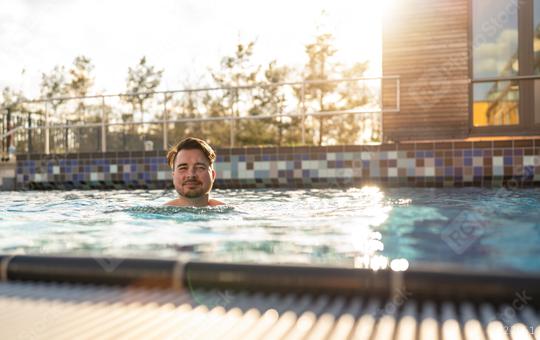 Man enjoying a relaxed swim in a pool at a hotel on sunset, sunl  : Stock Photo or Stock Video Download rcfotostock photos, images and assets rcfotostock | RC Photo Stock.: