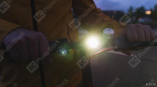 man holds electric kick scooter with lamp at night in the city, Electric urban transportation concept image  : Stock Photo or Stock Video Download rcfotostock photos, images and assets rcfotostock | RC Photo Stock.: