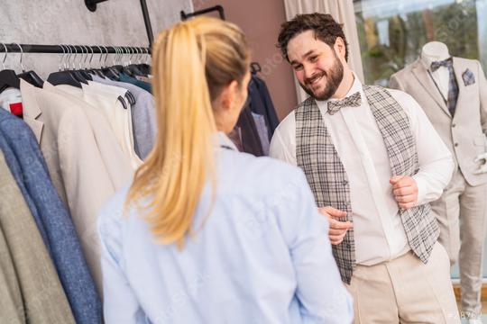 Man in vest smiling at tailor in clothing store, mannequin with suit in background  : Stock Photo or Stock Video Download rcfotostock photos, images and assets rcfotostock | RC Photo Stock.: