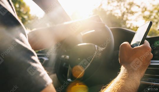 Man looking at mobile phone while driving a car  : Stock Photo or Stock Video Download rcfotostock photos, images and assets rcfotostock | RC Photo Stock.: