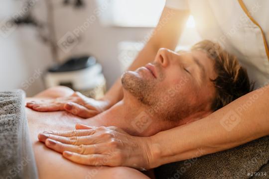 Man relaxing during a chest massage at a spa with a serene expression. Wellness Hotel Concept image  : Stock Photo or Stock Video Download rcfotostock photos, images and assets rcfotostock | RC Photo Stock.: