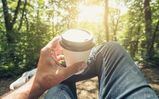 Man toasting coffee take away go cup against explosive sunlight in the forest. Point of view shot  : Stock Photo or Stock Video Download rcfotostock photos, images and assets rcfotostock | RC Photo Stock.: