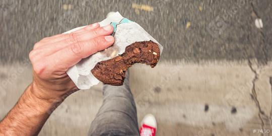 Man walking on sidewalk in the city street with bitten Chocolate Chip Cookie in his hand, point of view perspective.  : Stock Photo or Stock Video Download rcfotostock photos, images and assets rcfotostock | RC-Photo-Stock.: